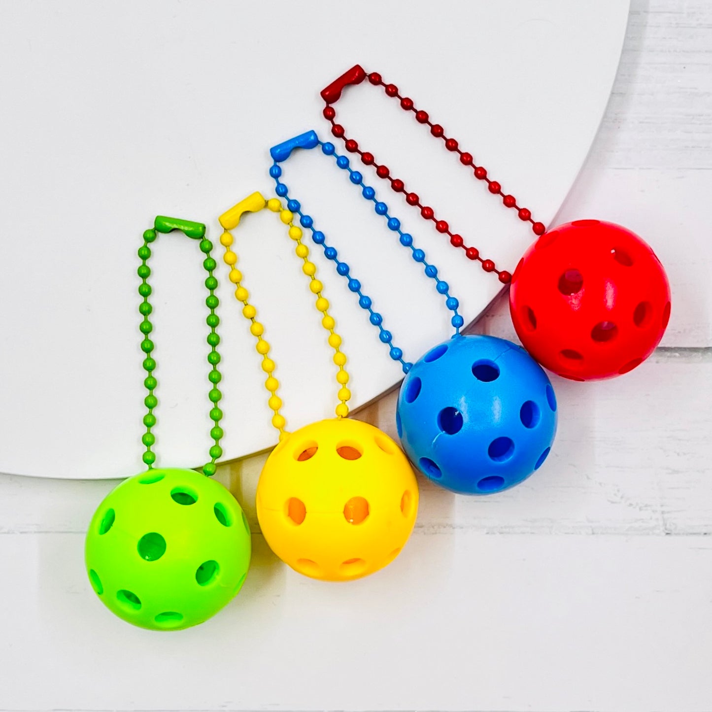 Micro Pickleball Bag Tags/Pulls (Set of 2)  Each order gets you 2 of the cutest little pickleball and chain! They measure about 1 inch and are used as bag tag markers. Fun for any bag, especially your pickleball bag!! The balls come in 4 colors: Red, Green, Blue, and Yellow. They now also come with matching chain colors!! Choose from 4 fun colors.