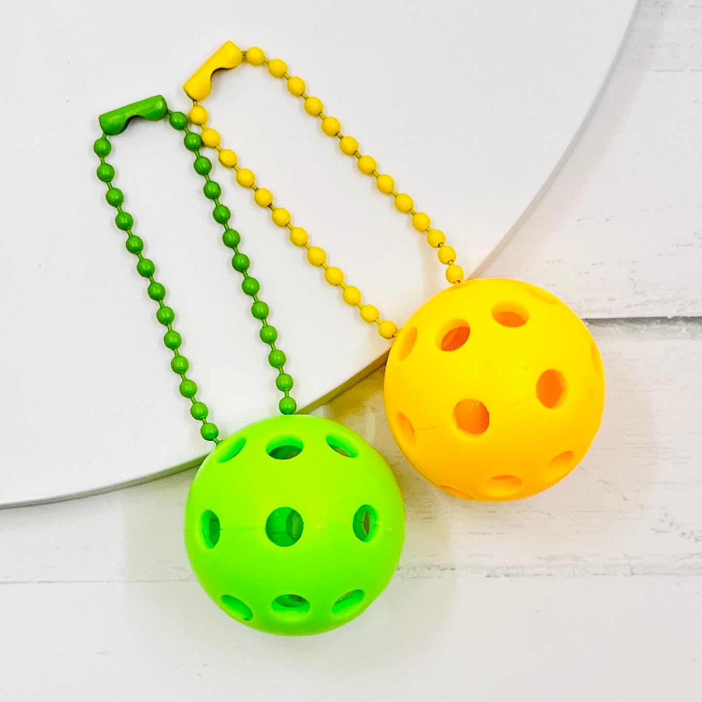 Micro Pickleball Bag Tags/Pulls (Set of 2)  Each order gets you 2 of the cutest little pickleball and chain! They measure about 1 inch and are used as bag tag markers. Fun for any bag, especially your pickleball bag!! The balls come in 4 colors: Red, Green, Blue, and Yellow. They now also come with matching chain colors!! Choose from 4 fun colors.