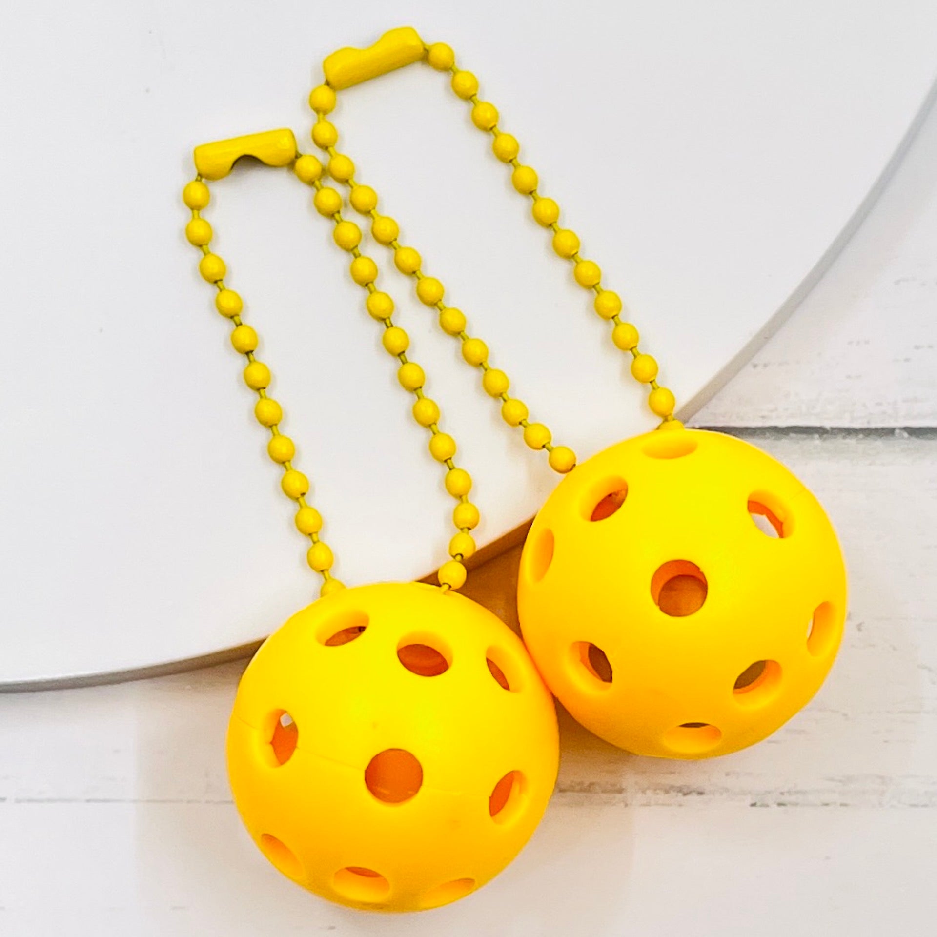 Micro Pickleball Bag Tags/Pulls (Set of 2)  Each order gets you 2 of the cutest little pickleball and chain! They measure about 1 inch and are used as bag tag markers. Fun for any bag, especially your pickleball bag!! The balls come in 4 colors: Red, Green, Blue, and Yellow. They now also come with matching chain colors!! Choose from 4 fun colors.