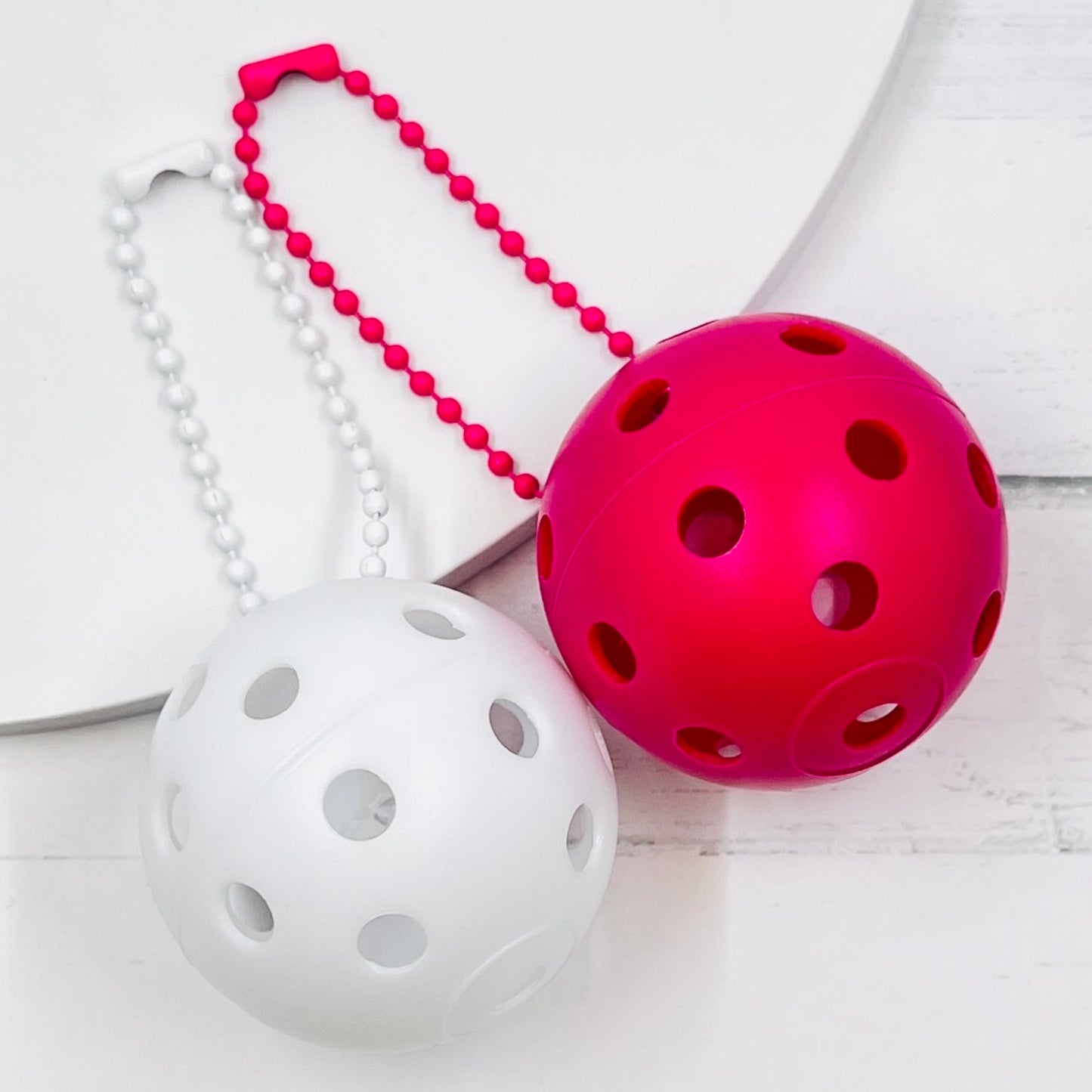 Mini Pickleball Bag Tags/Pulls (Set of 2)  Each order gets you 2 of the little mini pickleballs and chain! They measure about 1 1/2 inches and are used as bag tag markers. Fun for any bag, especially your pickleball bag!! The balls come in 7 colors: Red, Green, Blue, Orange, White, Pink, and Yellow. Choose 2 of the 7 fun colors.