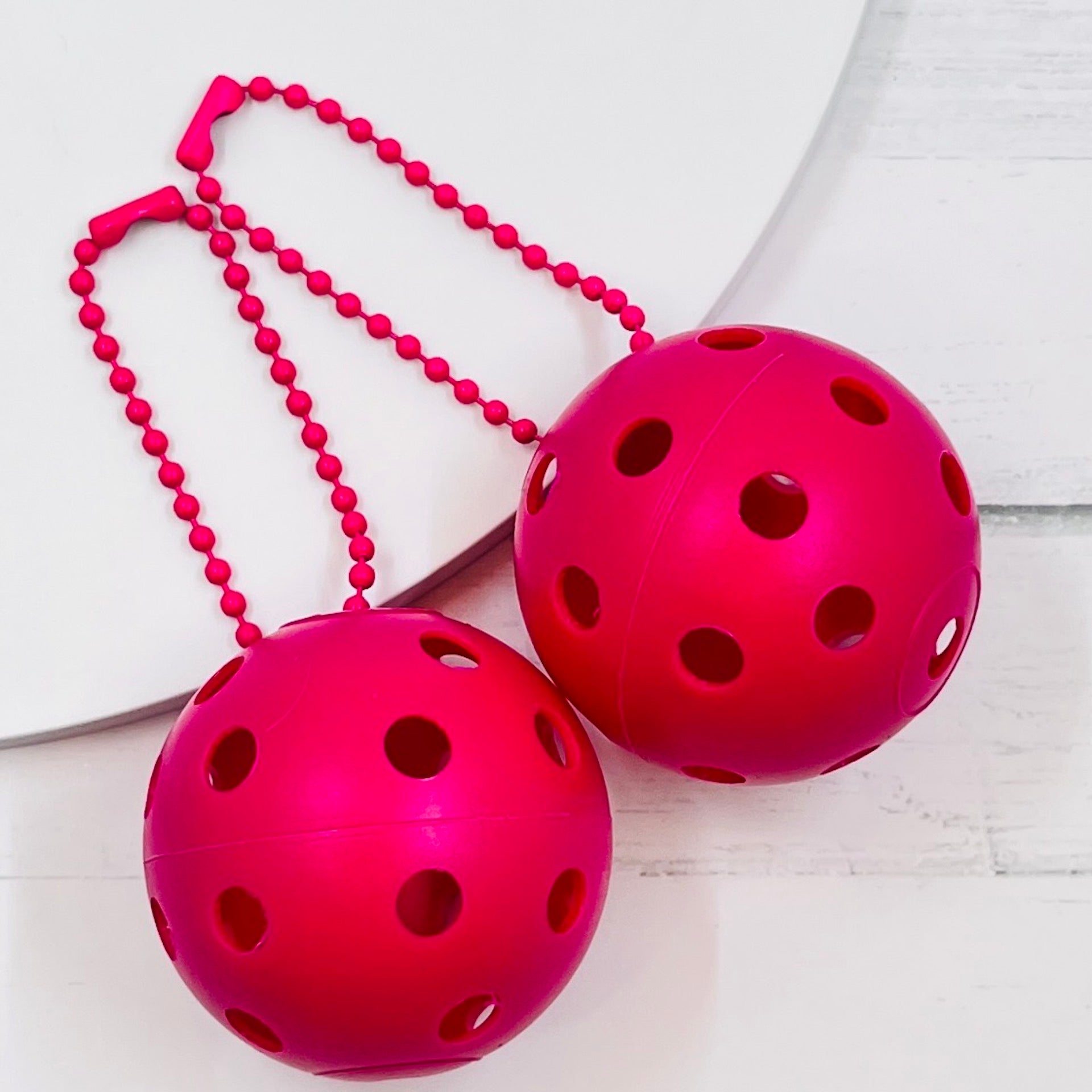 Mini Pickleball Bag Tags/Pulls (Set of 2)  Each order gets you 2 of the little mini pickleballs and chain! They measure about 1 1/2 inches and are used as bag tag markers. Fun for any bag, especially your pickleball bag!! The balls come in 7 colors: Red, Green, Blue, Orange, White, Pink, and Yellow. Choose 2 of the 7 fun colors.