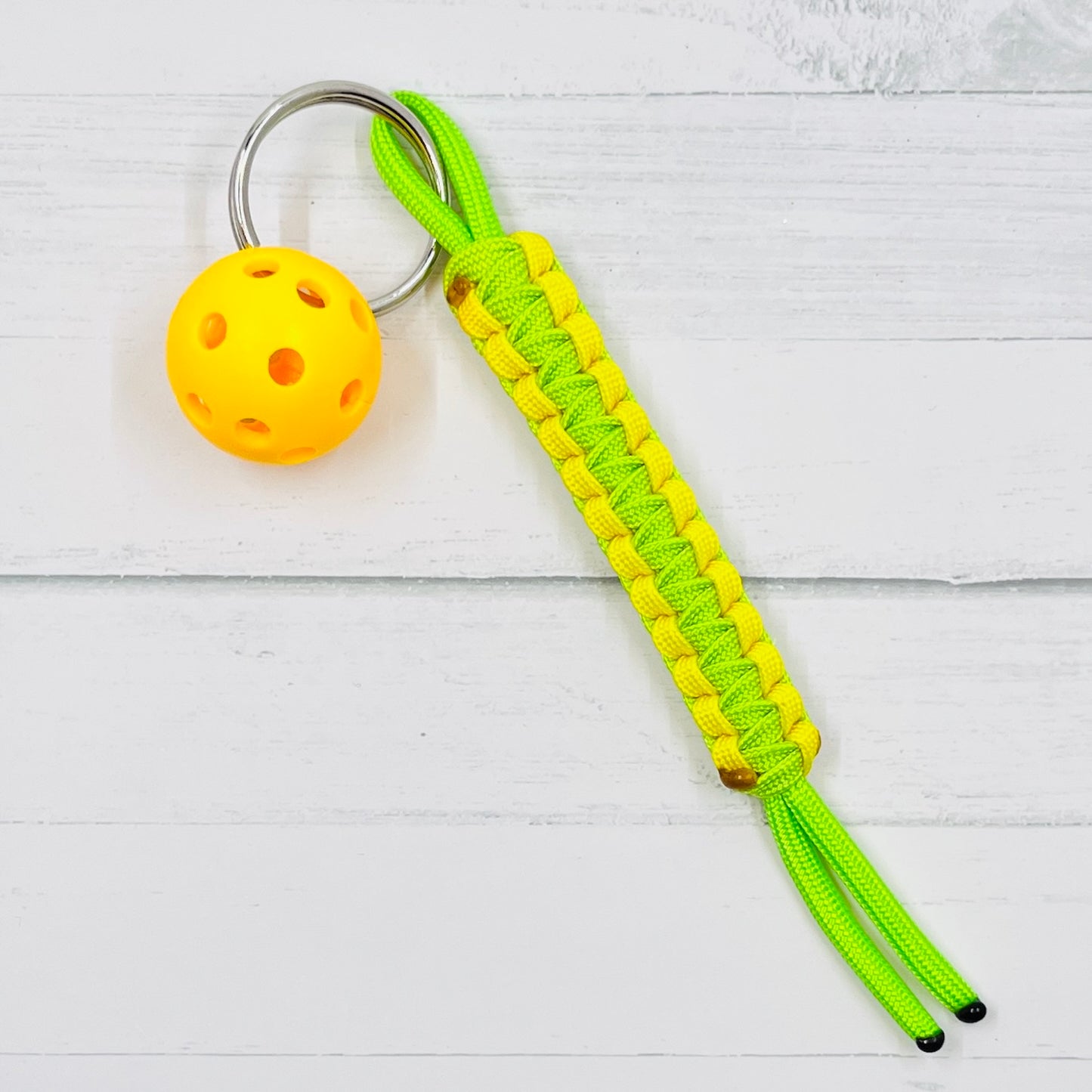 Micro Pickleball Keychain with Pull Tag Lanyard  This keychains are one-a-kind. They are super heavy duty and guaranteed to become your favorite keychain ever. There are multiple colors to choose from (and custom requests are available when possible). You also get to choose the color of ball you would like.  These keychains make it is so much easier to find your keys, especially in a purse. They are easy to carry also.