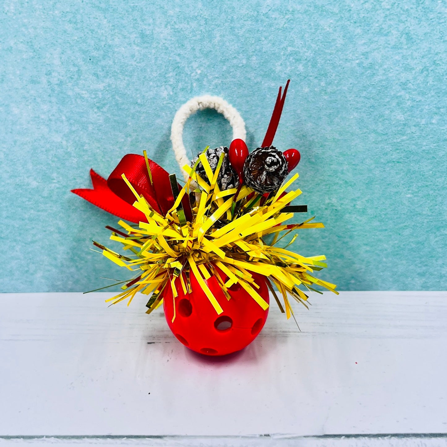 Colorful Pickleball Mistletoe.  Three sizes and customize colors.  Pickleball Christmas all year! It’s 2020, so why not? Perfect as a gift for yourself or others. It takes up very little space for all the RV pickleballers out there. This pickleball mistletoe can be hung in the doorway or used as a Christmas tree ornament. The pickleball are adorned with plastic sprigs of holly and berries, hung with decorative ribbon. 