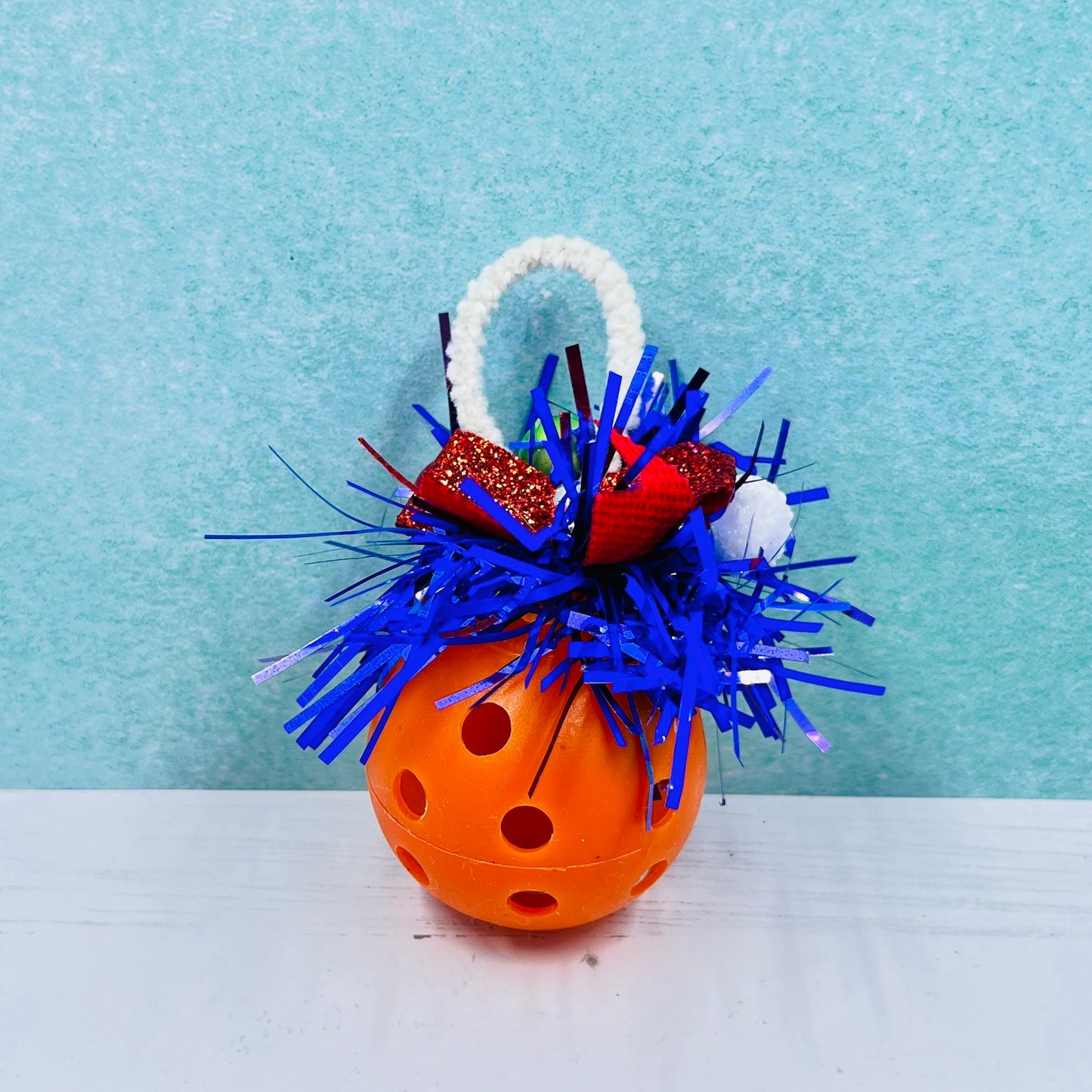 Colorful Pickleball Mistletoe.  Three sizes and customize colors.  Pickleball Christmas all year! It’s 2020, so why not? Perfect as a gift for yourself or others. It takes up very little space for all the RV pickleballers out there. This pickleball mistletoe can be hung in the doorway or used as a Christmas tree ornament. The pickleball are adorned with plastic sprigs of holly and berries, hung with decorative ribbon. 