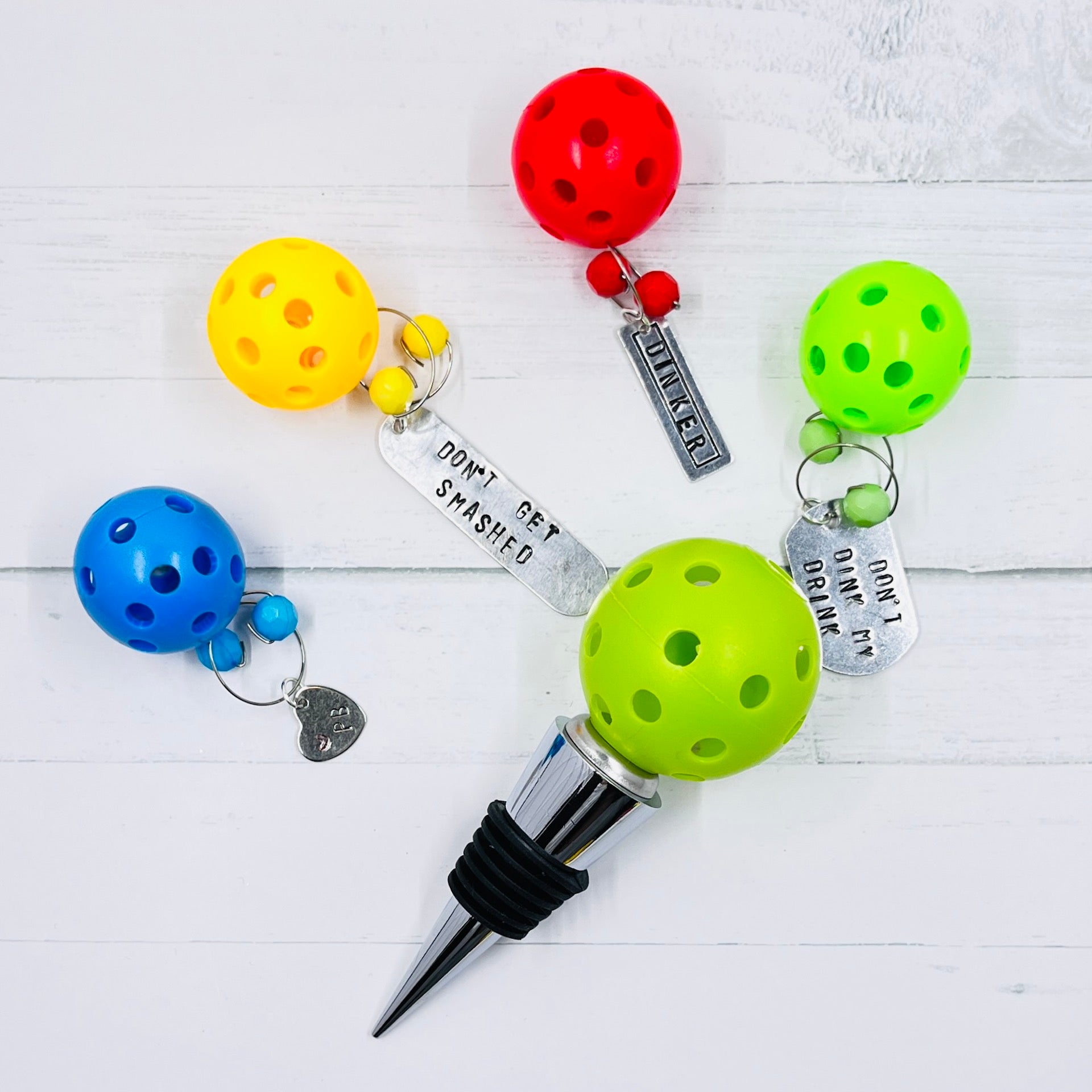 Pickleball Wine Stopper & Pickleball Wine Charms Combo  We have combined two of our most popular pickleball items to make the perfect gift for all your like-minded friends. Our wonderful pickleball wine bottle stoppers combined with four of our wine charms were meant to be together. Perfect gift for all special events such as tournaments, weddings, showers, birthdays, anniversary, etc. 