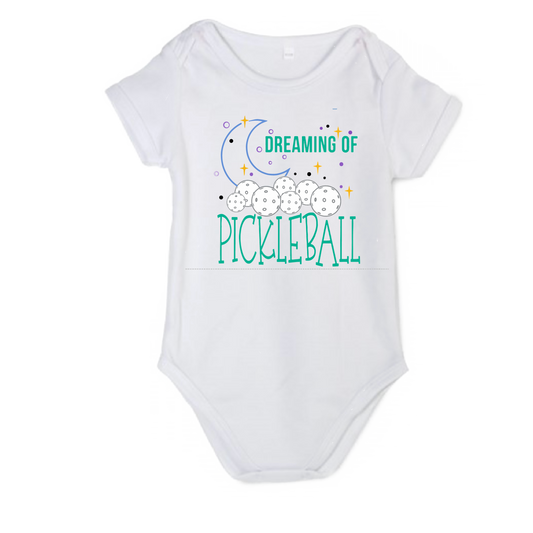 Pickleball Design: Dreaming of Pickleball  It’s a family affair! Show your love with these cute “Onesies” designed for the pickleball addict’s newest addition to the family. These unique designs are sure to please the fussiest of babies, parents and grandparents. Makes a perfect shower gift, birthday gift or just because gift.
