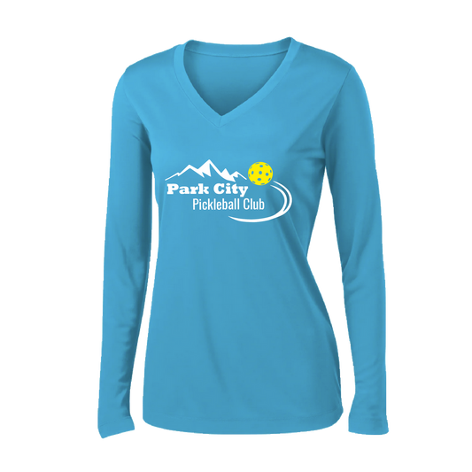 Pickleball Design: Park City Pickleball Club (white words)  Women's Style: Long Sleeve V-Neck  Turn up the volume in this Women's shirt with its perfect mix of softness and attitude. Material is ultra-comfortable with moisture wicking properties and tri-blend softness. PosiCharge technology locks in color. Highly breathable and lightweight.