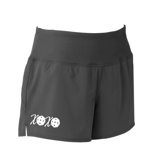 Pickleball Shorts Designs: XOXO  Sport Tek women’s repeat shorts come with built-in cell phone pocket on the exterior of the waistband. You can also feel secure knowing that no matter how strenuous the exercise, the shorts will remain in place (it won’t ride up!). These shorts are extremely versatile and trendy. Transition from the Pickleball court to running errands smoothly.