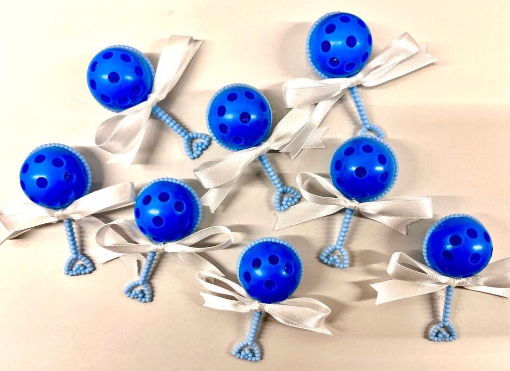 Pickleball Baby Shower Favors - Set of Eight Tiny Rattles with Micro Pickleballs  For all the future pickleball pros, these baby shower favors are a must have. The rattles measures only 2.5" long and approximately 1" wide. These would make super cute cupcake toppers for all future pickleball pros!!  These adorable favors are sure to delight all your pickleball friends and are the prefect addition to your celebration. Show your love of pickleball and spice up the party's atmosphere at the same time.