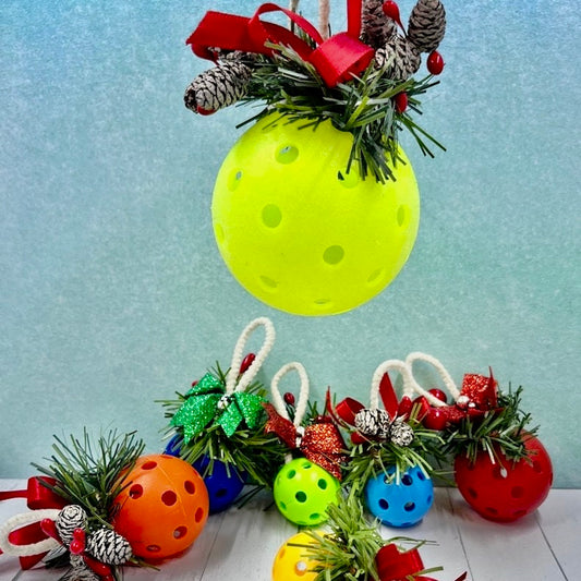 Pickleball Mistletoe  Each order gets you one mistletoe. Pickleball Christmas all year! Perfect as a gift for yourself or others. It takes up very little space for all the RV pickleballers out there. This pickleball mistletoe can be hung in the doorway or used as a Christmas tree ornament. The pickleball are adorned with plastic sprigs of holly and berries, hung with decorative ribbon and come in three sizes and many colors